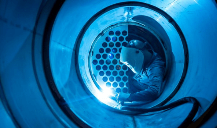 Homem trabalhando em ambiente regulamentado pela Norma NR33